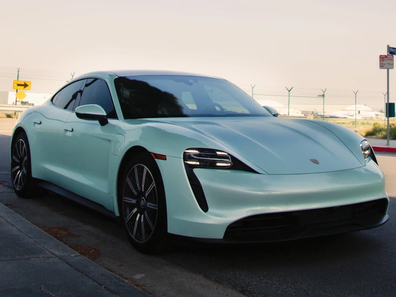 Porsche Taycan with mint green vinyl wrap — color change wraps do not trigger DMV notification in California