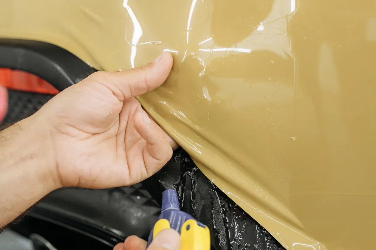 Desert Sand Color PPF being installed on a Porsche Macan body panel